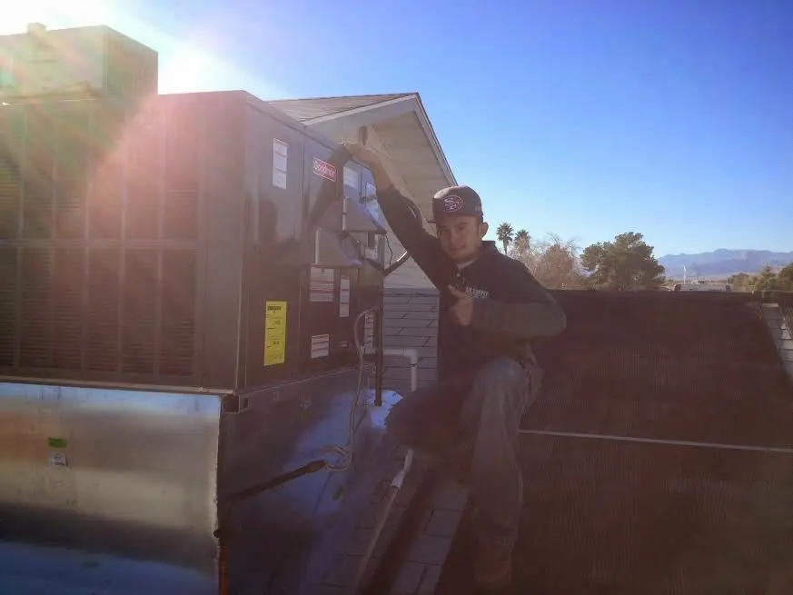 HVAC technician performing AC Tune-Up on a rooftop unit in Franklin